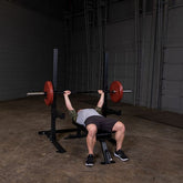 A person performing a bench press on the Body-Solid Pro Clubline SFB125 Flat Bench with weights on the bar.